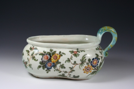 Bourdaloue in Italian majolica from Pesaro.  Polychrome decoration known as ‘a tacchiolo’. Eighteenth century. Private Collection. The name ‘Bordaloue’, used to indicate a type of chamber pot, derives from the French Jesuit preacher Louis Bourdaloue (1632–1704). He was so highly regarded that he was commissioned to preach sermons to King Louis XIV and his court in the Royal Chapel at Versailles. His sermons were so long, however, that the ladies of the court had to make arrangements to have the necessary vase near to hand, should the occasion call for it, to avoid having to absent themselves during the proceedings. The bourdaloue was an ever-present feature of an eighteenth century noblewoman’s daily life. Obviously, it was charged to the care of the servants. 