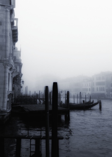 In the fog, the halos of lanterns attached to the tops of pilings shimmered on the Canal. The light reflecting on the surface of the dark water rose and fell, broke and recomposed, as if it were, itself, liquid and dense. From The Laws of Time, a novel by Andrea Perego Photo ©AndreaPerego