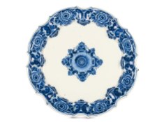 One of three large plates from Bassano, made by G.B. Antonibon, circa 1728–1738 Majolica a gran fuoco in blue monochrome Diameter: 56.5 cm Circular body with flat base, multilinear scalloped and convex edges, outer border lightly ribbed. Delft-type decoration (also know as “bull’s eye”) featuring large flowers and highly stylised leaves arranged radially along the edges. In the centre, a star-shaped corolla pattern with stylised leaves. Private Collection.
